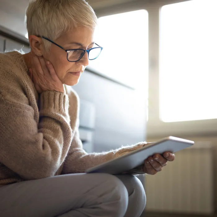 a sitting woman reading off her tablet