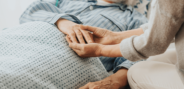 cancer patient on bed with care giver