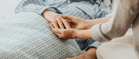 cancer patient on bed with care giver