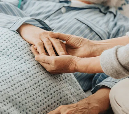 cancer patient on bed with care giver